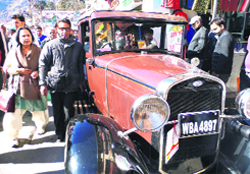 Tourists pose for a picture in front of the vintage beauties in Mussoorie on Monday. A Tribune photograph