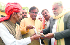 Farmers present a cheque, iron and soil to BJP national vice-president Purushottam Rupala at Dhakla village on Monday. Tribune photo