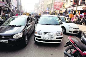 In absence of parking lots at Gumat market in Jammu, vehicles are seen parked on roads causing traffic jams