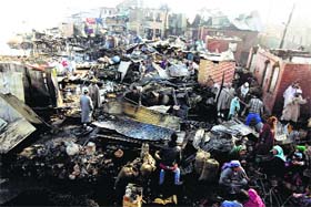 Locals sift through debris of their residential houses, which were gutted in a fire that broke out in the Dhobi Ghat locality at Hazratbal, Srinagar, on Monday
