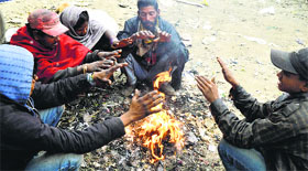 Workers sit around a bonfire on Jalandhar bypass in Ludhiana.