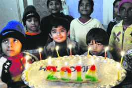Children light candles to usher in the year 2014 in Bathinda on New Year Eve