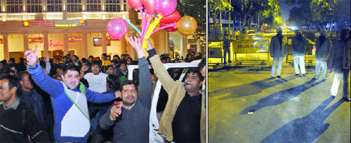 People all set to welcome 2014 at Connaught Place. (right) Delhi Police personnel manage the security at Janpath on the New Year Eve in New Delhi on Tuesday.