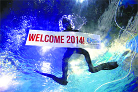 A diver holds a "Welcome 2014" banner in Manila.