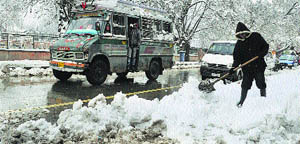 A man clears snow from a footpath in Srinagar on Wednesday. The city received one of the heaviest snowfalls since 1996. 
