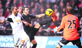 Swansea City's Chico Flores (L) challenges Manchester City's Alvaro Negredo (C) during their EPL match on Wednesday
