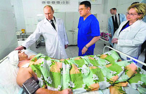 Russian President Vladimir Putin comforts a victim injured in recent terrorist attacks as he visits a hospital in Volgograd on Wednesday. 