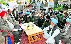 Affected farmers discuss their strategy at a gurdwara in Saini Majra on Thursday