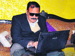 Rajinder Monga works on laptop at his home in Bathinda on Friday.