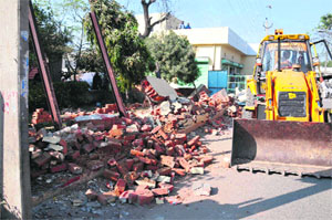 The demolished compound wall of a hospital at the Dr Mela Ram road in Bathinda on Friday.