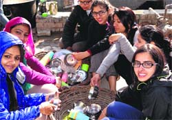 NSS volunteers of Panjab University clean utensils after having community lunch during a camp on Friday. A Tribune photograph