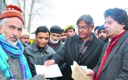 Kashmir University Vice Chancellor distributes relief to Hazratbal fire victims on Friday. A tribune photograph