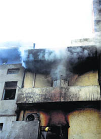 Smoke coming out of the cosmetics shop located in the Gur Mandi area of Ludhiana on Friday.