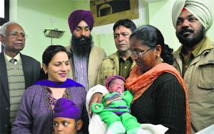 Abandoned baby girl in the lap of Jasbir Kaur, president of Swami Ganganand Bhuriwale International Foundation, at Juneja Hospital in Ludhiana. 
