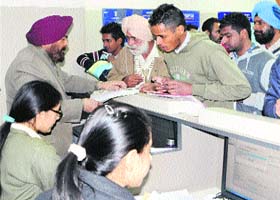Regional Passport Officer JS Sodhi (left) helps people during a passport mela organised at the Seva Kendra in Amritsar on Saturday
