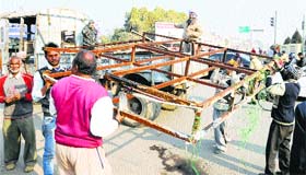 A Municipal Corporation team removes an illegal hoarding at Bhandari Bridge in Amritsar on Saturday