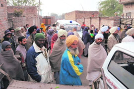 People gather outside the house of the couple; and (below left) a woman with the 3-month-old girl that survived the incident at Baba Deep Singh Nagar in Bathinda on Saturday.