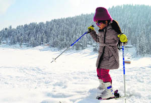 A girl enjoys skiing in Gulmarg on Saturday. 