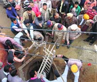 Residents try to rescue the labourer trapped in the tank. Photo: Inderjeet Verma 