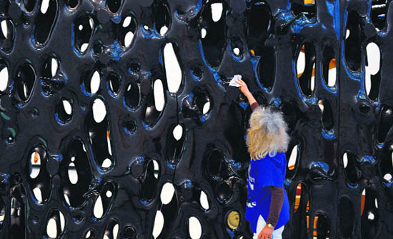 A woman cleans a piece of art during the preparation of the exhibition “Non Basta Ricordare — Collezione MAXXI” during a press review at the MAXXI museum in Rome. The exhibition will run till September 28, 2014.