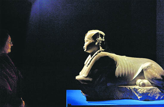 A woman looks at a sphinx sculpture during a press review of the exhibition Monsters, Fantastic Creatures of the Fear and the Myth at the Museo Nazionale Romano in the Palazzo Massimo in Rome.