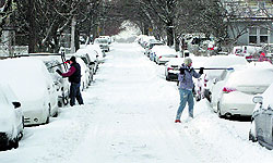People remove snow from their cars in New York on Friday