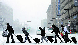 People leave the subway station during a snowstorm in Massachusetts on Friday