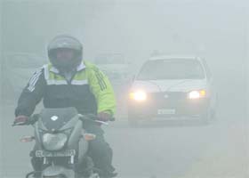 Commuters drive during the foggy morning in New Delhi on Sunday