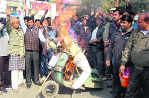Members of the BJYM burn an effigy of the Central Government at Clock Tower in Dehradun on Sunday to protest the hike in fuel prices.