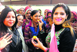 Avantika Maken Tanwar, MP Ashok Tanwars wife, offers sweets to Reena Birat, the newly appointed district Mahila Congress president, in Sirsa on Sunday. 