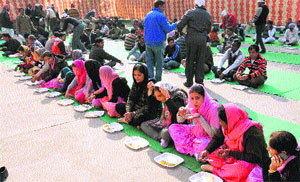 People partake of langar organised by the employees at the District Administrative Complex (DAC) in Bathinda on Monday.