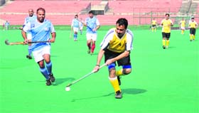 Players vie for the ball during the North Zone Audit Tournament at the Hockey Stadium in Sector 42, Chandigarh, on Monday