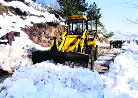 An earthmover clearing snow from the Mughal Road in Poonch on Monday