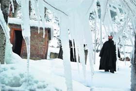 A man looks on as icicles are formed on his house near Daksum in South Kashmirs Anantnag district on Monday