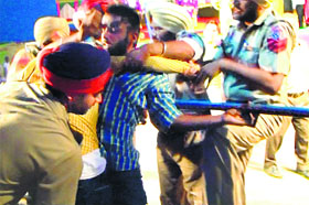 The picture that Naresh Sehgal had sent to the Governor with his complaint, showing the police picking up a youth before his death at the Dasehra Ground in Kotkapura.