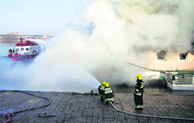 Rescuers try to extinguish a fire as thick plumes of smoke rise over a raft restaurant caught fire in Belgrade, Serbia, on Monday.