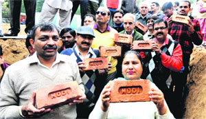 Residents carrying bricks with BJP prime ministerial candidate Narendra Modis name engraved on them at the foundation laying ceremony of a community centre at Sector 15, Chandigarh, on Tuesday.