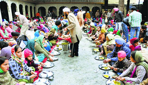 Devotees partake of langar on the birth anniversary of Guru Gobind Singh in Jammu on Tuesday. 