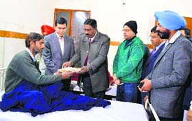 DC Rajat Aggarwal and founder of the Ann Jal Sewa Trust Shiv Ram Saroy offer food to a drug addict at a de-addication centre in Ludhiana