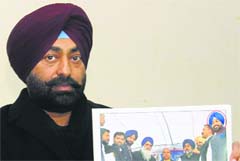 Sukhpal Khaira shows accused Bittu Aulakhs picture with the Deputy CM. a tribune photo