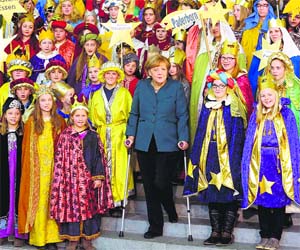 German Chancellor Angela Merkel stands on crutches as she attends the annual reception for Carolers at the chancellery in Berlin on Tuesday. AP/PTI