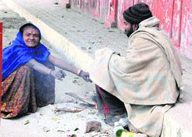 Destitutes brave the chill around a bonfire on the roadside near Company Bagh in Amritsar