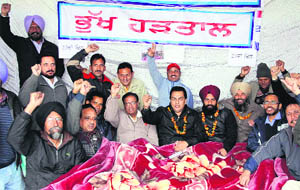 PUDA employees sit on a dharna in front of their office in Jalandhar on Wednesday. 