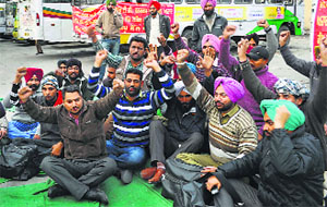 PRTC employees hold a protest at the Patiala bus stand on Wednesday.