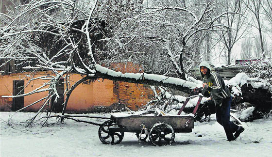 A vendor pushes a handcart after light snowfall in Srinagar