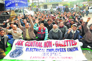 Members of the J&K Central Non-Gazetted Electrical Employees Union protest outside the exhibition ground in Jammu on Thursday. 