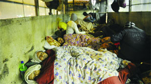 Outstation patients take shelter in the abandoned buses near AIIMS in New Delhi on Friday. 
