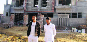 Rajesh Siwach (right) with another resident in front of a house under construction.