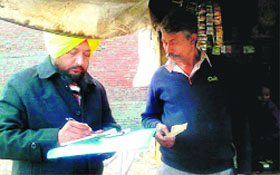 A Health Department employee issues challans at a shop in Amritsar on Saturday.