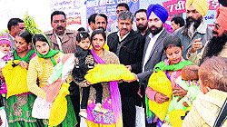 Chairman of the Zila Parishad Gurpreet Maluka and Chief Parliamentary Secretary Sarup Chand Singla felicitate girls during the Dheeyan Di Lohri programme in Bathinda on Saturday